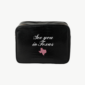 Black travel bag with 'See you in Texas' text and a pink Texas outline on a white background