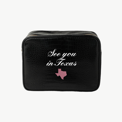 Black travel bag with 'See you in Texas' text and a pink Texas outline on a white background