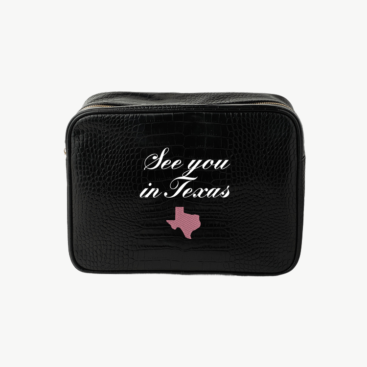 Black travel bag with 'See you in Texas' text and a pink Texas outline on a white background