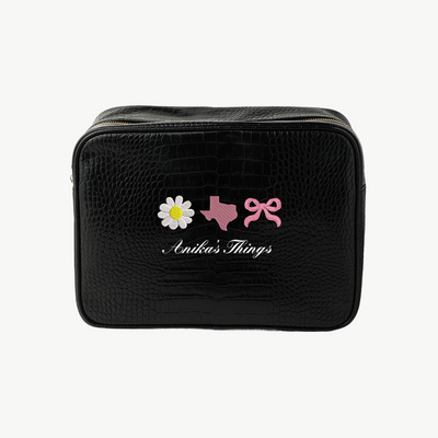Black toiletry bag with decorative elements and 'Anikas Things' branding on a white background