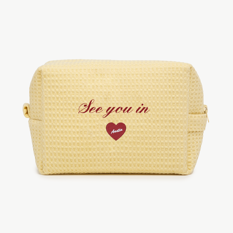Yellow textured pouch with 'See you in Austin' text and heart design on a white background