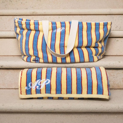 Striped bag with monogram on a wooden surface