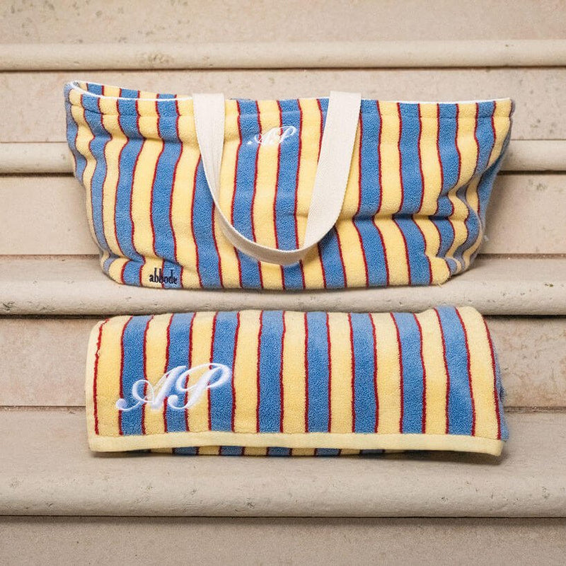 Striped bag with monogram on a wooden surface