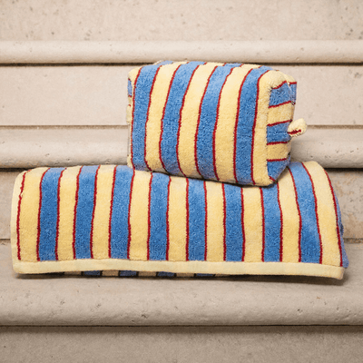 Striped pouch and towel on a wooden surface.