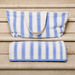 Blue and white striped bag and towel on wooden steps