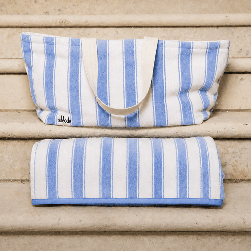 Blue and white striped bag and towel on wooden steps